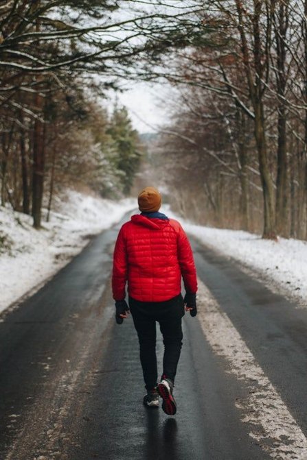 Young man walking on a snowy road