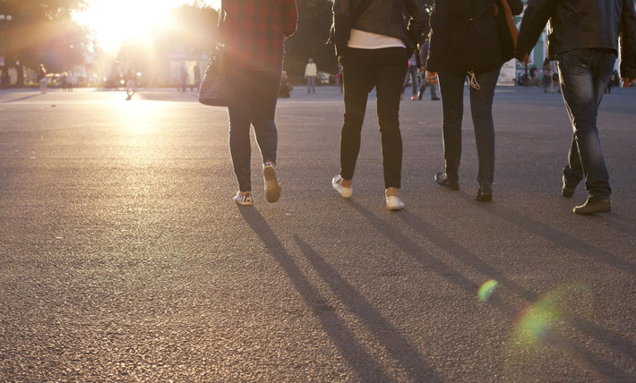 Group of friends walking toward a sun.